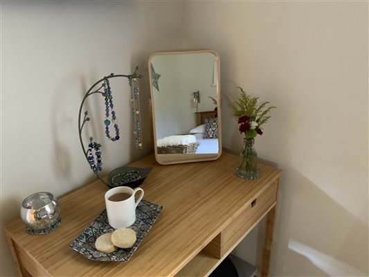 dressing table with mirror at the back and coffee on a tray